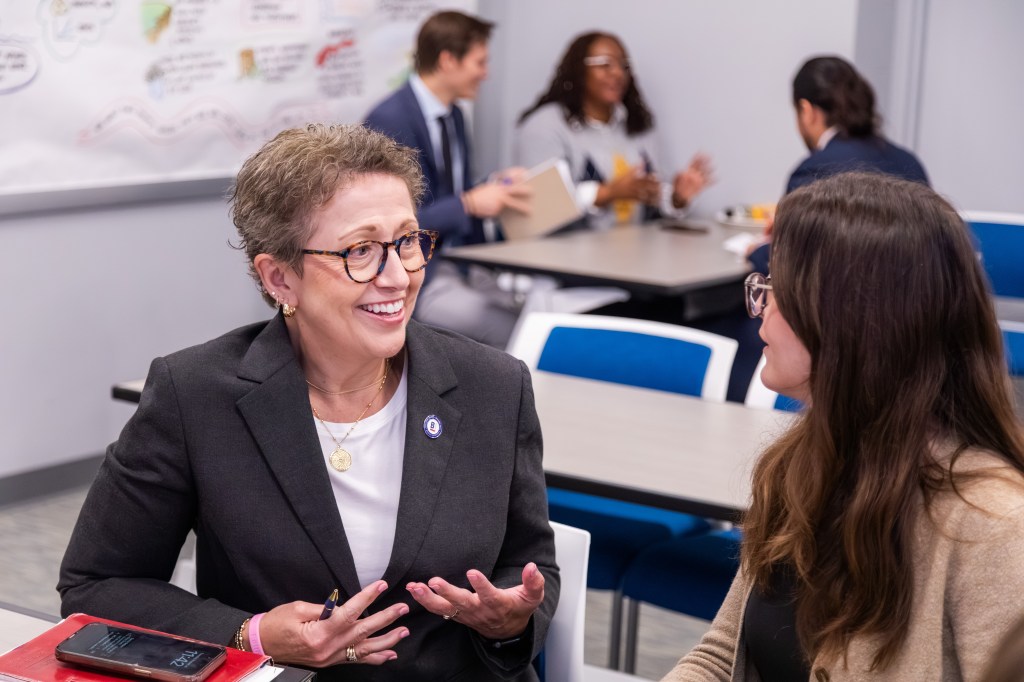 Dr. Jaeger talking to a team member at a table.